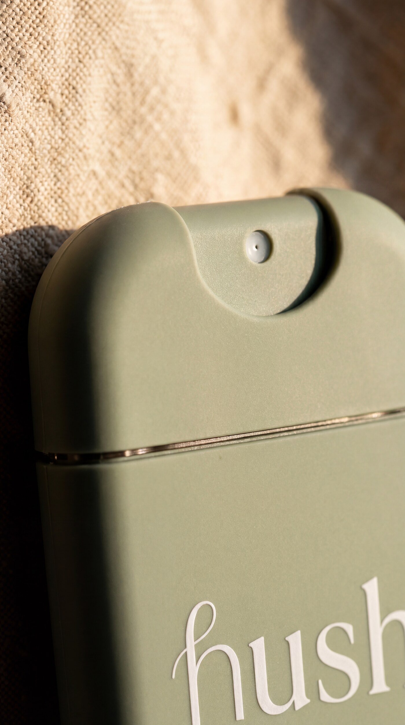 Hush bottle macro detail — matte sage silicone, hinged spray nozzle